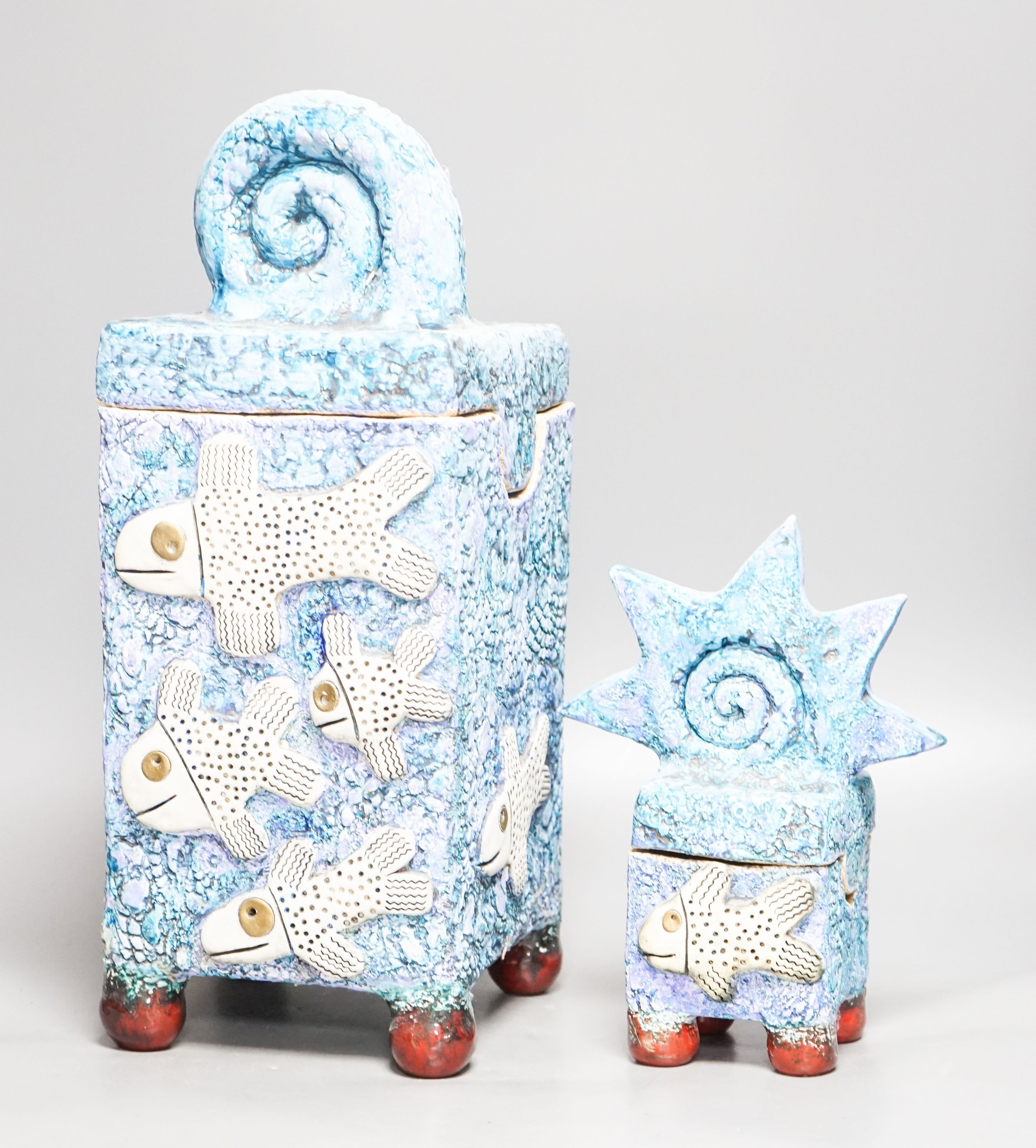 Gio Martin, a large square 'fish' jar and cover and a similar smaller jar and cover 44cm